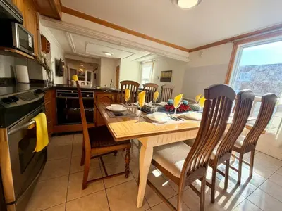a kitchen with a wooden table with chairs and a stove at City Lights Loft-Free Parking-Sleep 18 in Montréal