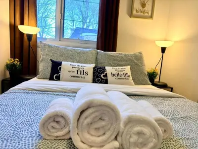 a bed with white towels on it with a window at City Lights Loft-Free Parking-Sleep 18 in Montréal