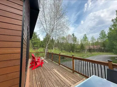 a wooden deck with two red benches on it at Vacances Magiques Chalet Skadi Paix Nature in Saint-Justin