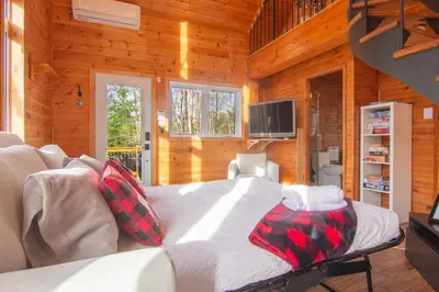 a bedroom with a bed in a room with wooden walls at Vacances Magiques Chalet Skadi Paix Nature in Saint-Justin
