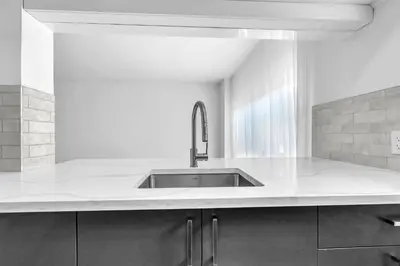 a kitchen with a sink and a white counter top at Sophisticated Two Bedroom Hideaway in Westmount in Montréal