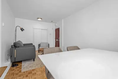 a white room with a white table and chairs at Sophisticated Two Bedroom Hideaway in Westmount in Montréal