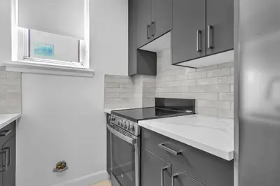 a kitchen with gray cabinets and a stove at Sophisticated Two Bedroom Hideaway in Westmount in Montréal