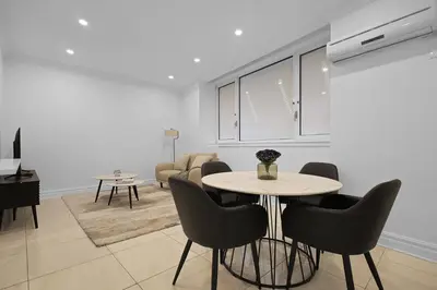 a dining room and living room with a table and chairs at Sophisticated Two Bedroom Hideaway in Westmount in Montréal