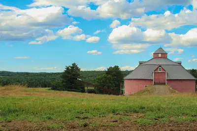a red barn sitting on top of a field at Le domaine Primavesi in West Brome
