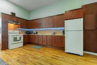 a kitchen with wooden cabinets and a white refrigerator at Trendy 2BR Getaway in Montreal in Montréal