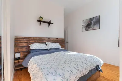 a bedroom with a bed with a wooden headboard at Trendy 2BR Getaway in Montreal in Montréal