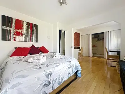 a bedroom with a large bed with red pillows at Charmant appartement de 2 pièces et proche du Métro in Laval