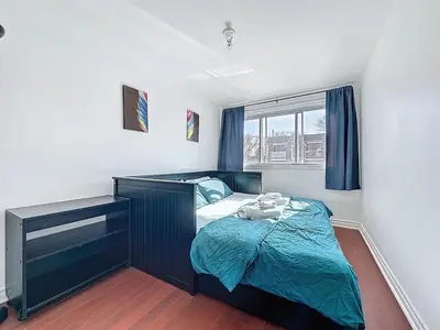 a bedroom with a bed and a desk and a window at Charmant appartement de 2 pièces et proche du Métro in Laval