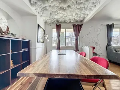 a dining room with a wooden table and pink chairs at Charmant appartement de 2 pièces et proche du Métro in Laval