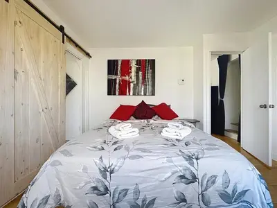 a bedroom with a large bed with red pillows at Charmant appartement de 2 pièces et proche du Métro in Laval