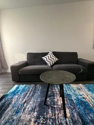 a living room with a black couch and a table at The FIVE in Montréal