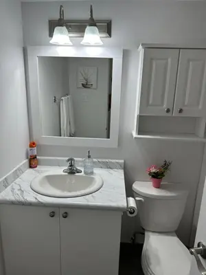 a bathroom with a sink and a toilet and a mirror at The FIVE in Montréal