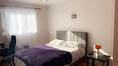a bedroom with a bed and a table and a window at Private bedroom in Montréal
