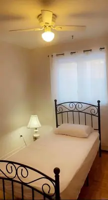 a bedroom with a bed with a ceiling fan at Private bedroom in Montréal