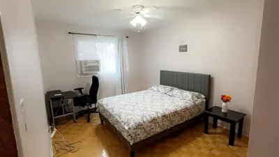a bedroom with a bed and a desk and a window at Private bedroom in Montréal