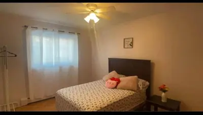 a bedroom with a bed with a ceiling fan at Private bedroom in Montréal
