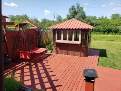 a playground with a swing and a play house at La campagne en ville avec spa in Laval