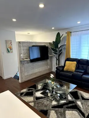 a living room with a couch and a tv at Luxury bungalow in Châteauguay