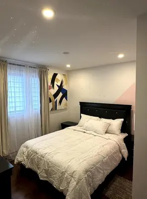 a bedroom with a large bed and a window at Luxury bungalow in Châteauguay