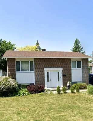 a brown brick house with a white garage at Luxury bungalow in Châteauguay