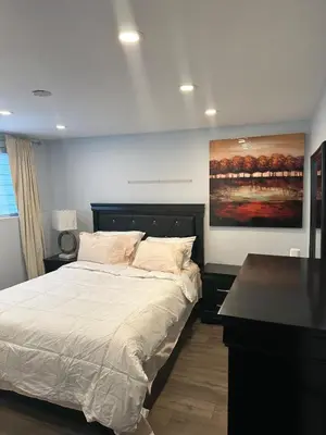a bedroom with a bed and a painting on the wall at Luxury bungalow in Châteauguay