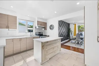 a kitchen with white countertops and a dining room at Luxury bungalow in Châteauguay