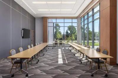 a conference room with tables and chairs and large windows at Staybridge Suites Montreal Airport - St-Laurent by IHG in Montréal