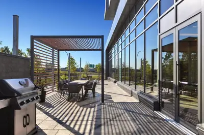 an outdoor patio with tables and chairs on a building at Staybridge Suites Montreal Airport - St-Laurent by IHG in Montréal