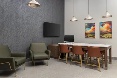 a waiting room with a table and chairs and a laptop at Staybridge Suites Montreal Airport - St-Laurent by IHG in Montréal