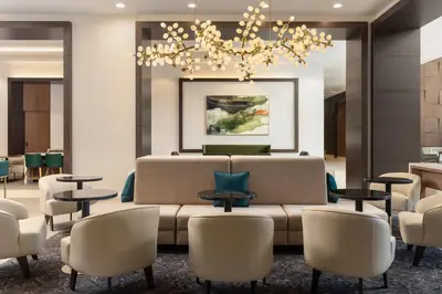 a lobby with a couch and chairs and a chandelier at Staybridge Suites Montreal Airport - St-Laurent by IHG in Montréal