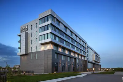 a large office building with lights on at Staybridge Suites Montreal Airport - St-Laurent by IHG in Montréal