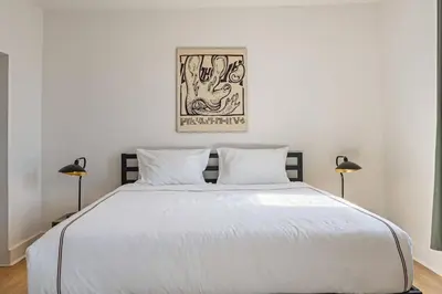 a bedroom with a large white bed with two lamps at The Slant - Trendy Spot in the Heart of Montreal in Montréal