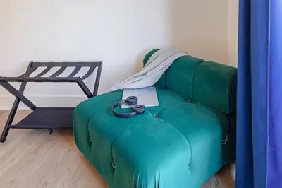 a green couch with a laptop on top of it at The Slant - Trendy Spot in the Heart of Montreal in Montréal