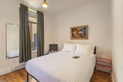a bedroom with a large white bed with a window at The Slant - Trendy Spot in the Heart of Montreal in Montréal