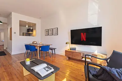 a living room with a large tv on the wall at The Slant - Trendy Spot in the Heart of Montreal in Montréal