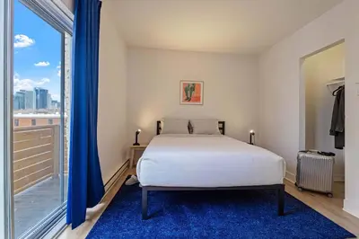 a bedroom with a bed and a large window at The Slant - Trendy Spot in the Heart of Montreal in Montréal