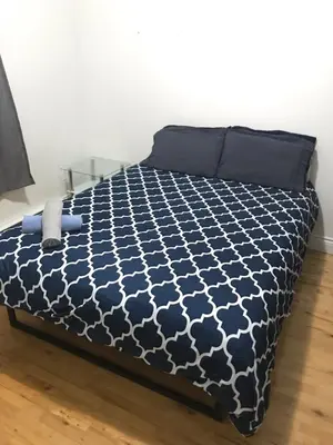 a bed with a black and white comforter at Full Unit METRO VERDUN Pet Friendly in Montréal