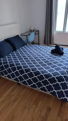 a bedroom with a bed with a blue comforter at Full Unit METRO VERDUN Pet Friendly in Montréal
