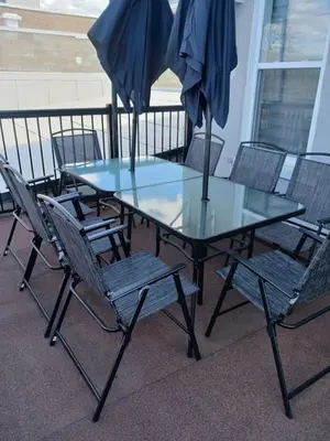 a glass table with chairs and an umbrella on a balcony at Modern 3 bedroom condo in Montréal