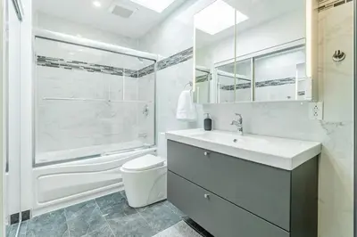 a bathroom with a sink and a toilet and a shower at Modern 3 bedroom condo in Montréal