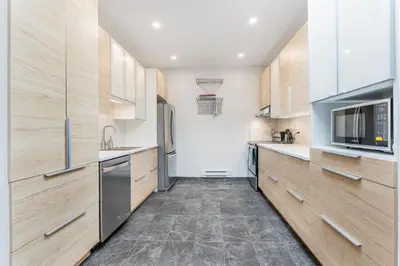 a kitchen with wooden cabinets and stainless steel appliances at Modern 3 bedroom condo in Montréal