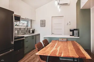 a kitchen with a wooden table in a kitchen at Le Pignon Vert in Sainte-Séraphine