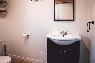 a bathroom with a sink and a mirror on the wall at Le Pignon Vert in Sainte-Séraphine