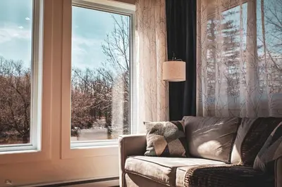 a living room with a couch and a window at Le Pignon Vert in Sainte-Séraphine