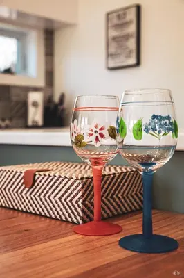 two wine glasses sitting on top of a wooden table at Le Pignon Vert in Sainte-Séraphine