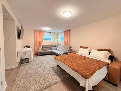 a bedroom with a bed and a living room at Confort & Harmonie in Longueuil