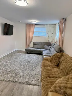 a living room with a couch and a television at Confort & Harmonie in Longueuil
