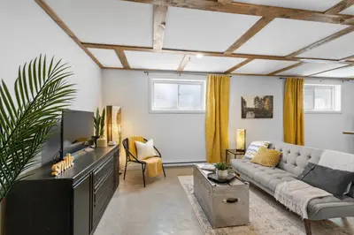 a living room with a couch and a tv at Le nid des hirondelles in Windsor