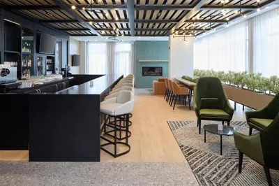 a lobby with a bar with chairs and tables at Hyatt Place Montreal Airport in Dorval